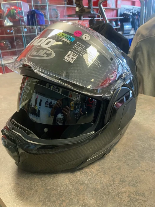 Intérieur d'un magasin spécialisé en équipements moto avec présentoirs et vitrines d'exposition