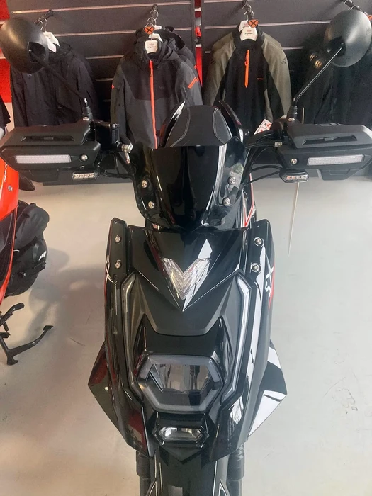 Motocyclette sportive Kawasaki noire et verte garée sur route asphaltée