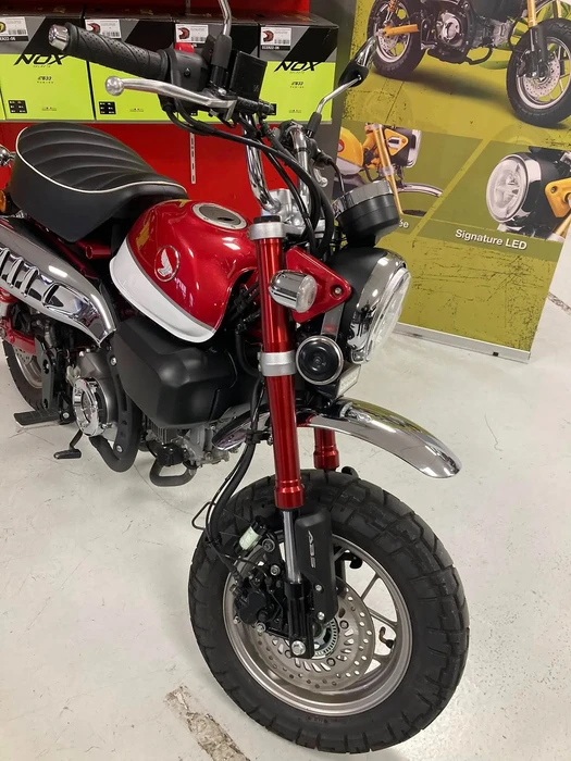 Intérieur d'un showroom de concessionnaire de scooters et motos avec plusieurs véhicules deux-roues exposés sur sol en béton ciré