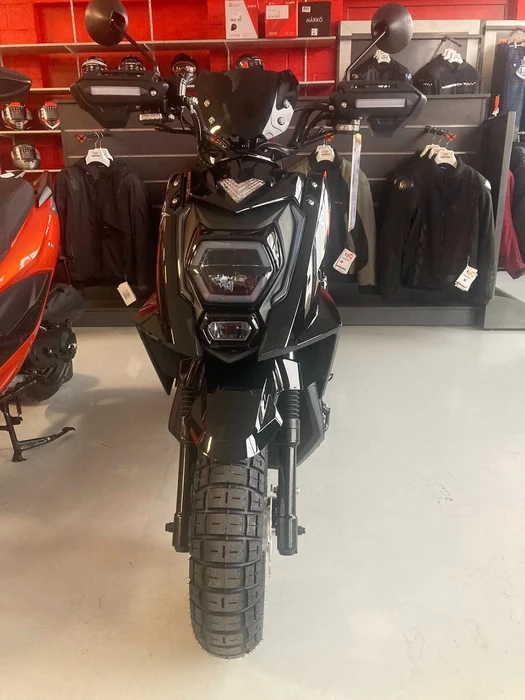 Showroom de concessionnaire moto avec scooter vintage rouge et blanc exposé au premier plan