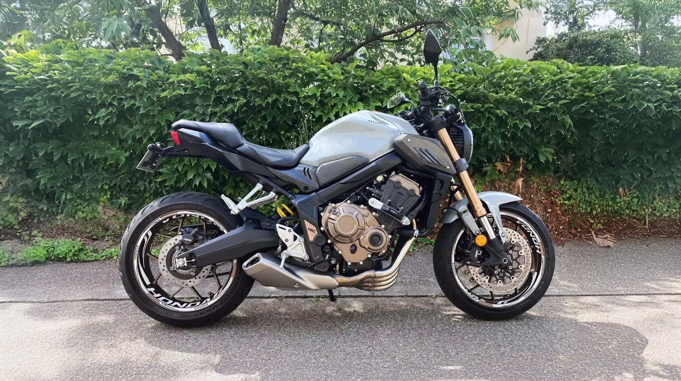 Moto sportive noire haute performance en studio sur fond blanc, positionnée en vue trois-quarts arrière